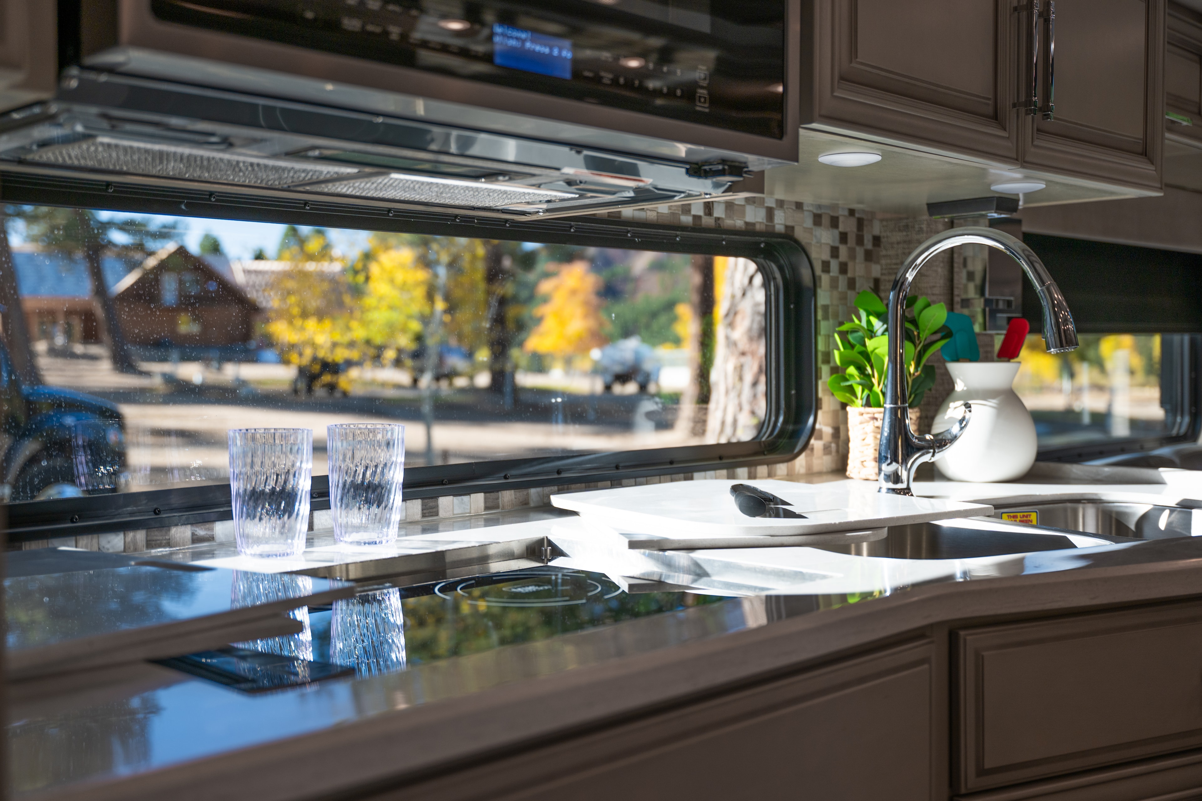 RV kitchen interior with resort grounds outside the window