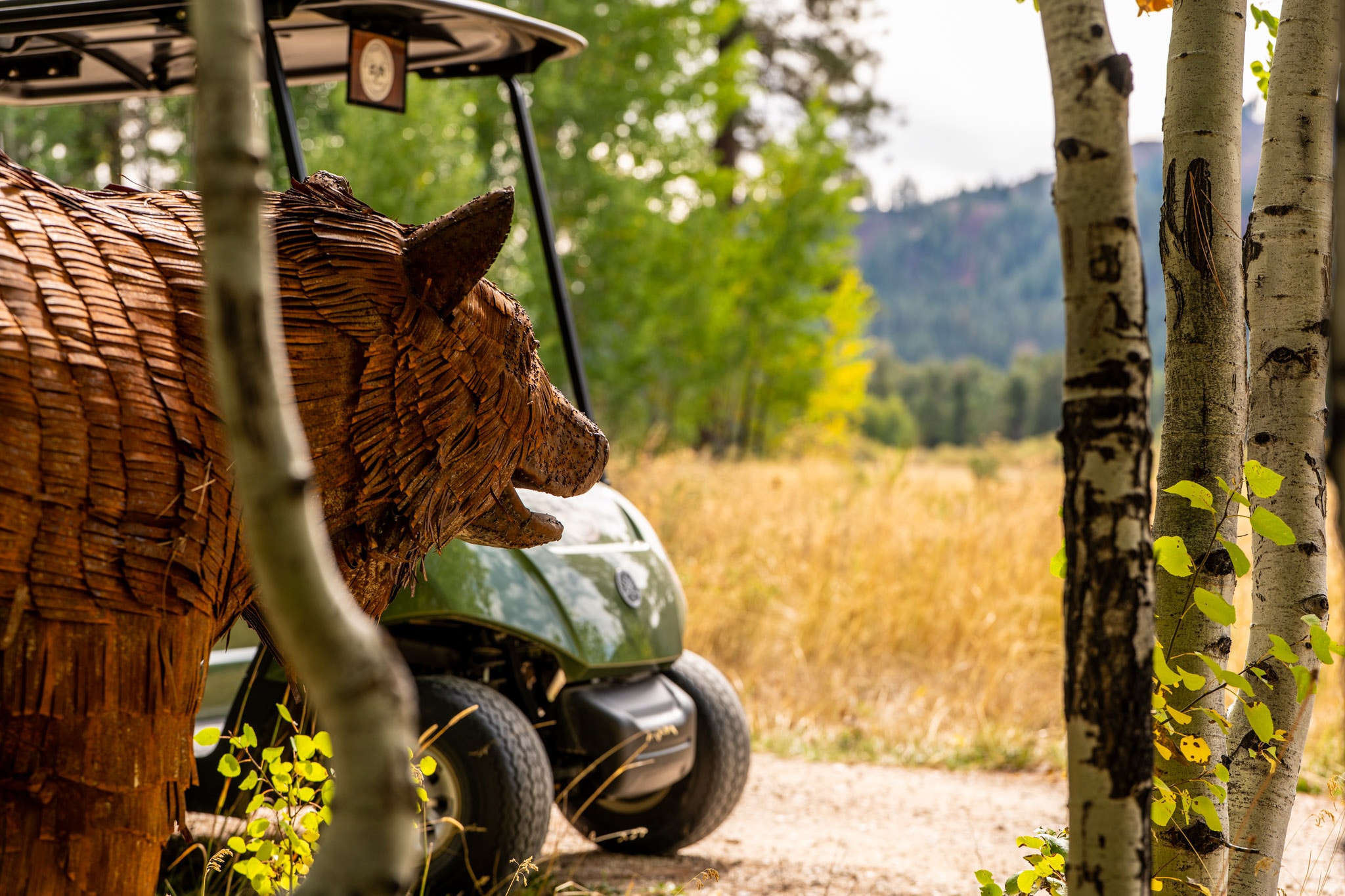 Carved bears beside a golf cart